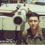 man standing in front of military tank