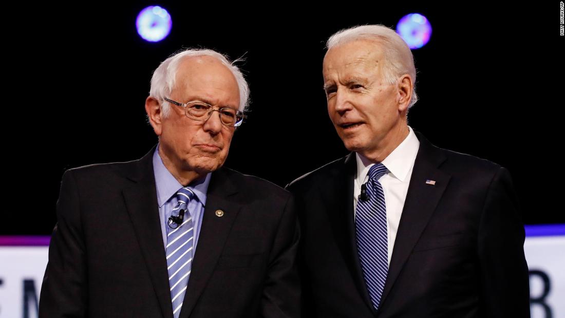 Sanders and former Vice President Joe Biden talk before a Democratic debate in Charleston, South Carolina, in February 2020.